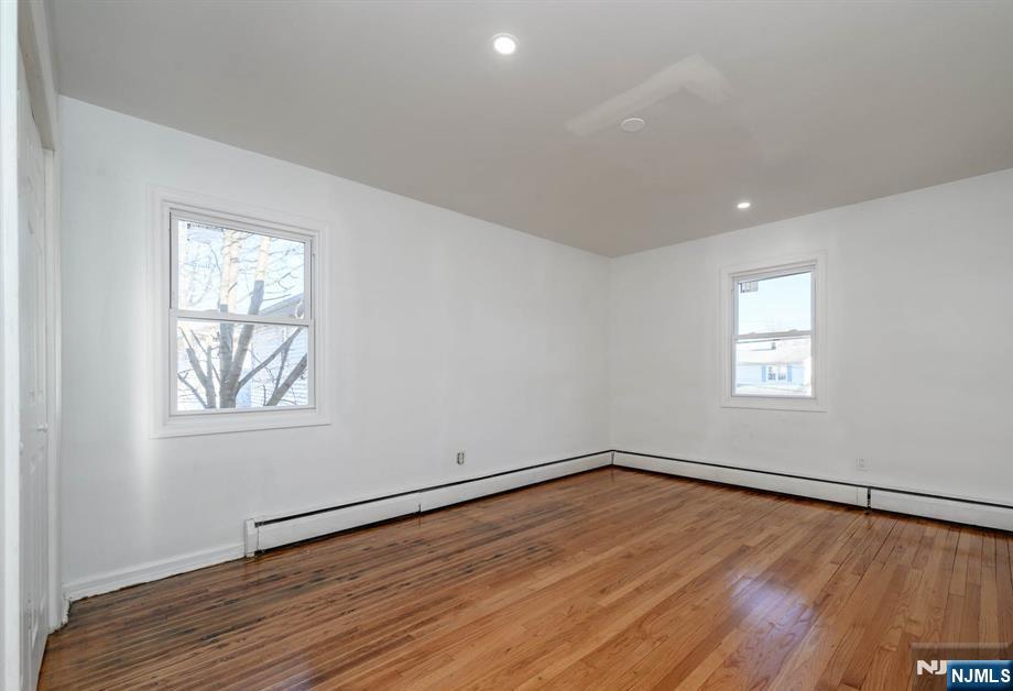 49 River Street, Unit 2 Lodi, NJ 07644 - Photo 18 of 24 an empty room with wooden floor and windows