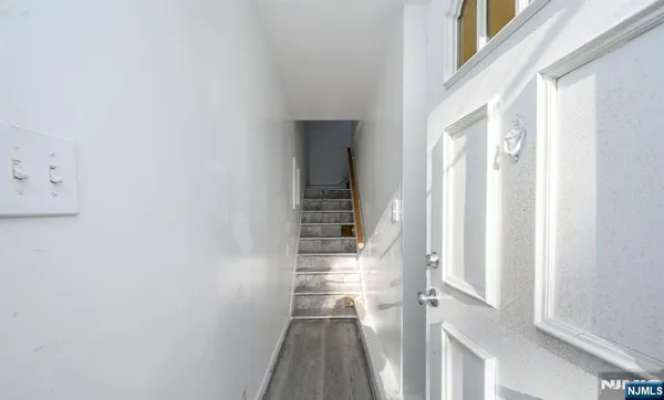 a view of a hallway with wooden floor and entryway