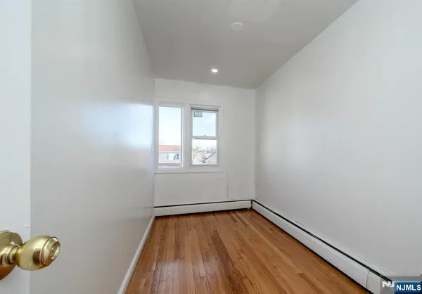 a view of room with window and wooden floor