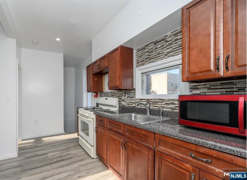 49 River Street, Unit 2 Lodi, NJ 07644 - Photo 5 of 24 a kitchen with stainless steel appliances granite countertop a sink stove and cabinets