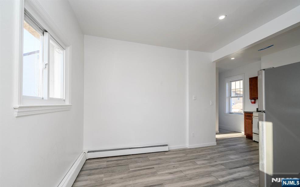49 River Street, Unit 2 Lodi, NJ 07644 - Photo 8 of 24 a view of an empty room with wooden floor and a window