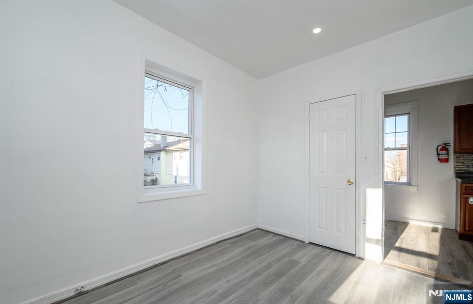 49 River Street, Unit 2 Lodi, NJ 07644 - Photo 10 of 24 an empty room with wooden floor and windows