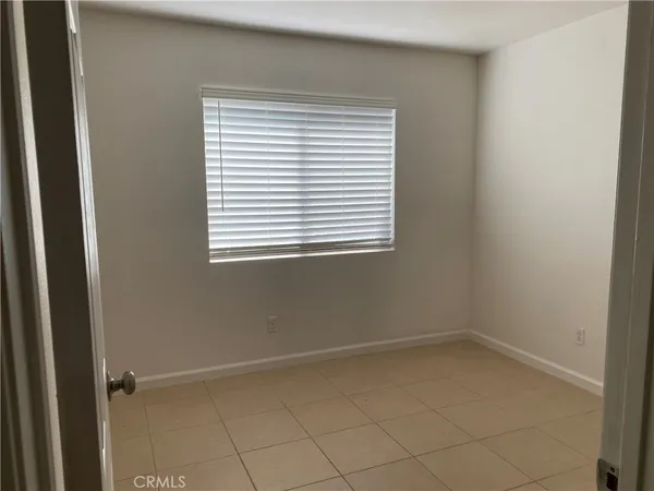 a view of an empty room with wooden floor and a cabinet