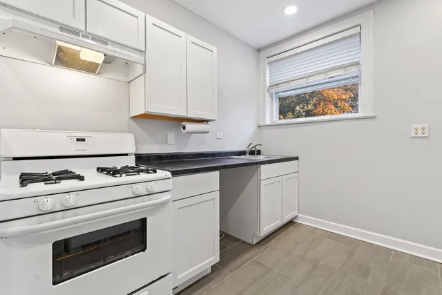 a kitchen with granite countertop white cabinets and white appliances