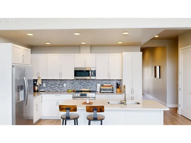 a kitchen with stainless steel appliances kitchen island granite countertop a sink and cabinets