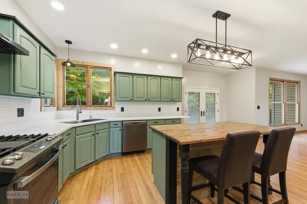 a kitchen with center island table and chairs in it
