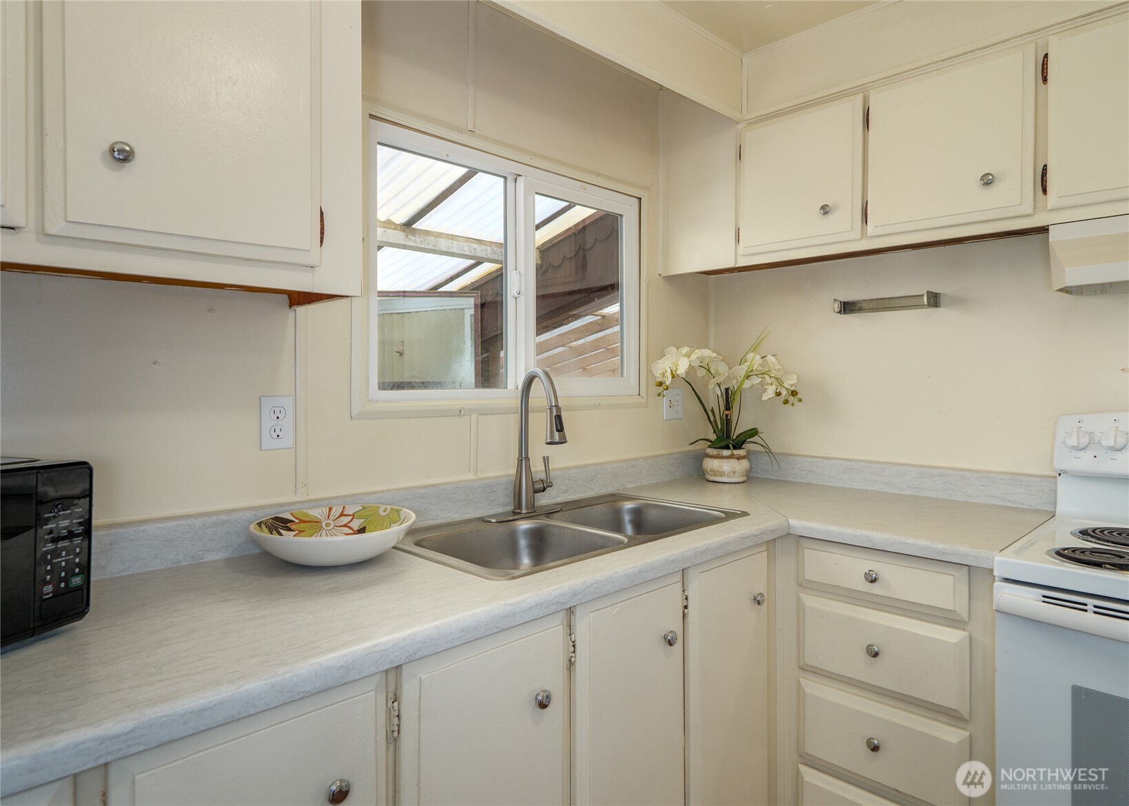 201 North 5th Avenue, Unit 19 Sequim, WA 98382 - Photo 13 of 25 a kitchen with white cabinets and a sink