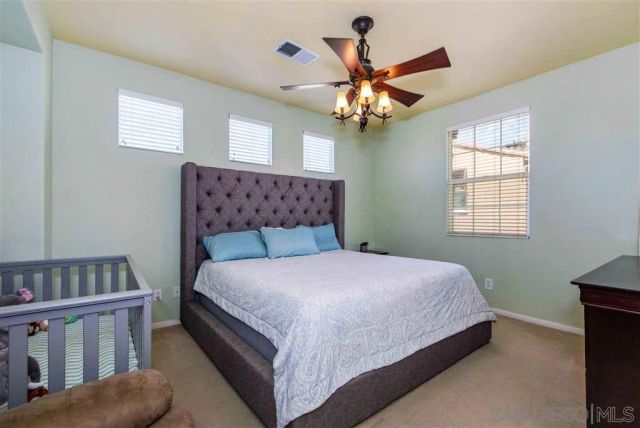 a bedroom with a large bed and a chandelier