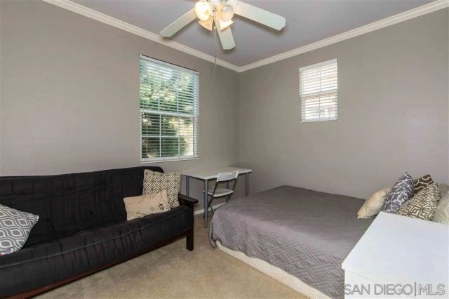 a bedroom with bed couch and window