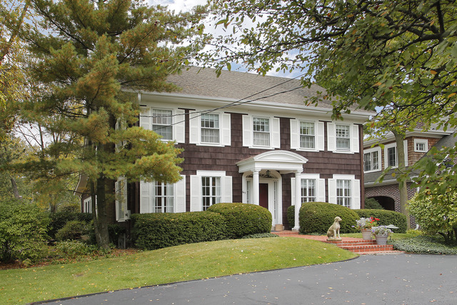 a front view of a house with yard and green space