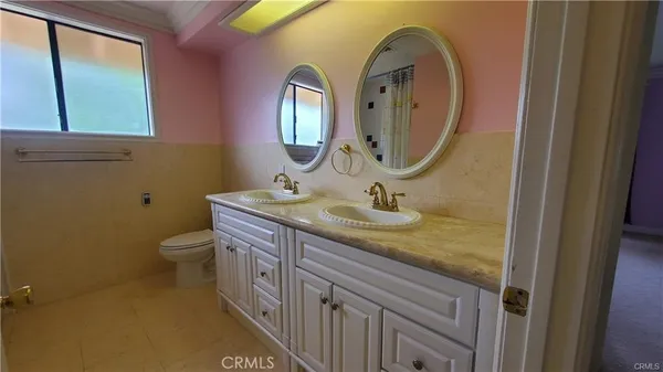 a bathroom with a granite countertop toilet a sink and a mirror