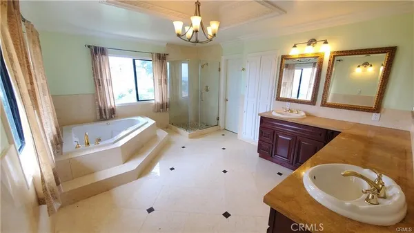 a spacious bathroom with a tub a double vanity sink and a mirror