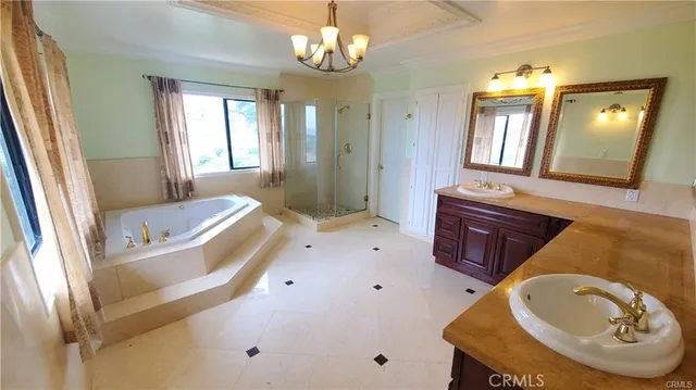 a spacious bathroom with a tub a double vanity sink and a mirror