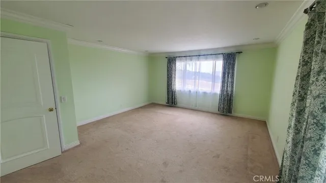 a view of a big room with windows and chandelier fan