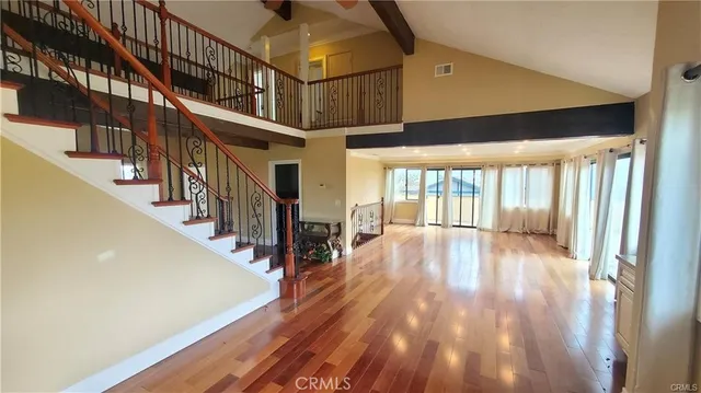 a view of staircase with lots of frames on wall and wooden floor