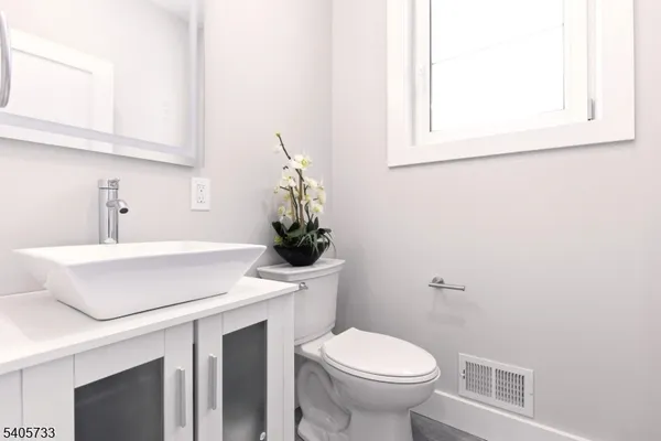 a bathroom with a sink a toilet and mirror