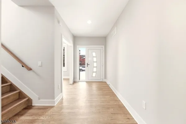 a view of a hallway with wooden floor and entryway