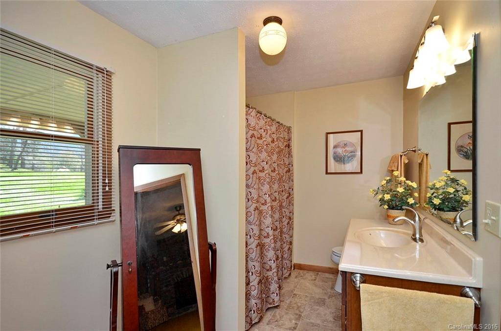 110-114 Hilltop Road Waynesville, NC 28786 - Photo 12 of 21 a bathroom with a sink a mirror and a shower