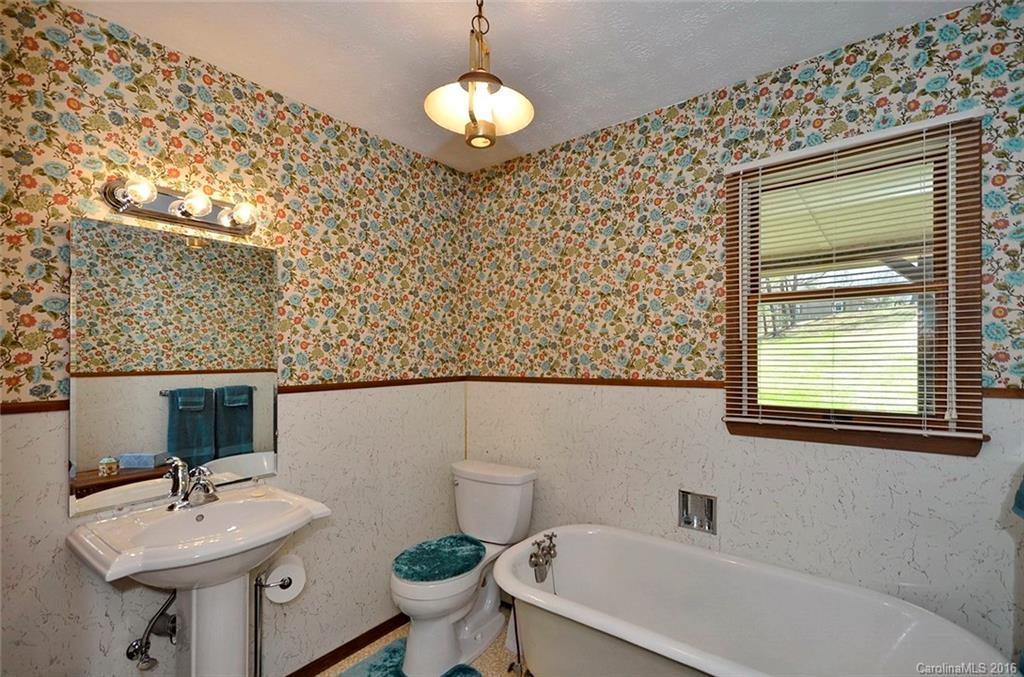 110-114 Hilltop Road Waynesville, NC 28786 - Photo 13 of 21 a bathroom with a sink a mirror and a toilet