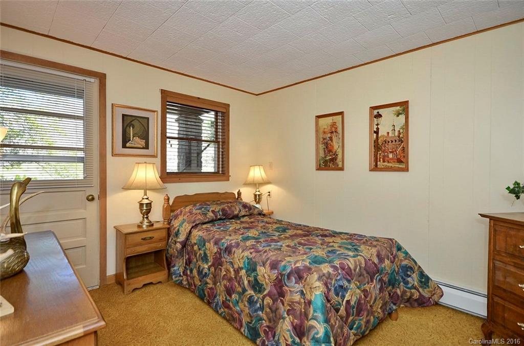 110-114 Hilltop Road Waynesville, NC 28786 - Photo 19 of 21 a bedroom with a bed and wooden floor