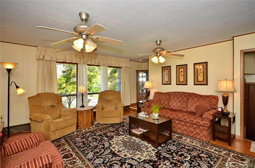 110-114 Hilltop Road Waynesville, NC 28786 - Photo 4 of 21 a living room with furniture a dining table and a chandelier