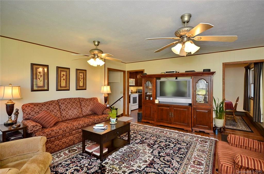 110-114 Hilltop Road Waynesville, NC 28786 - Photo 5 of 21 a living room with furniture a dining table and a chandelier