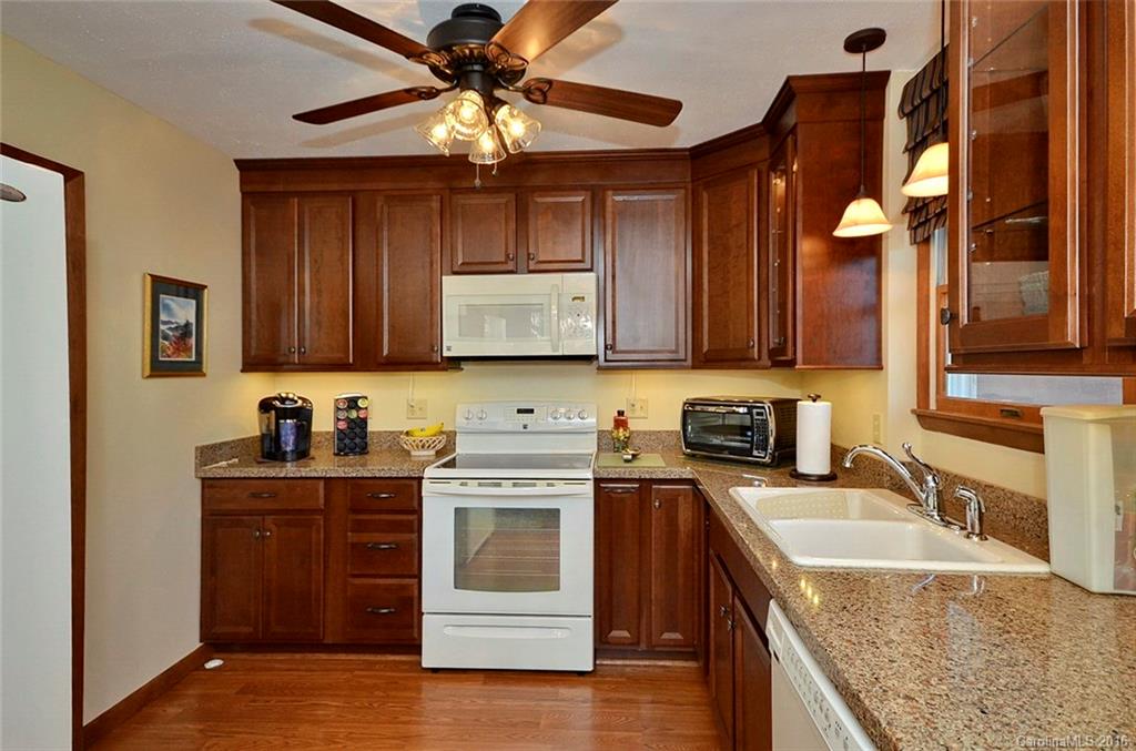 110-114 Hilltop Road Waynesville, NC 28786 - Photo 6 of 21 a kitchen with stainless steel appliances granite countertop a sink a stove and cabinets