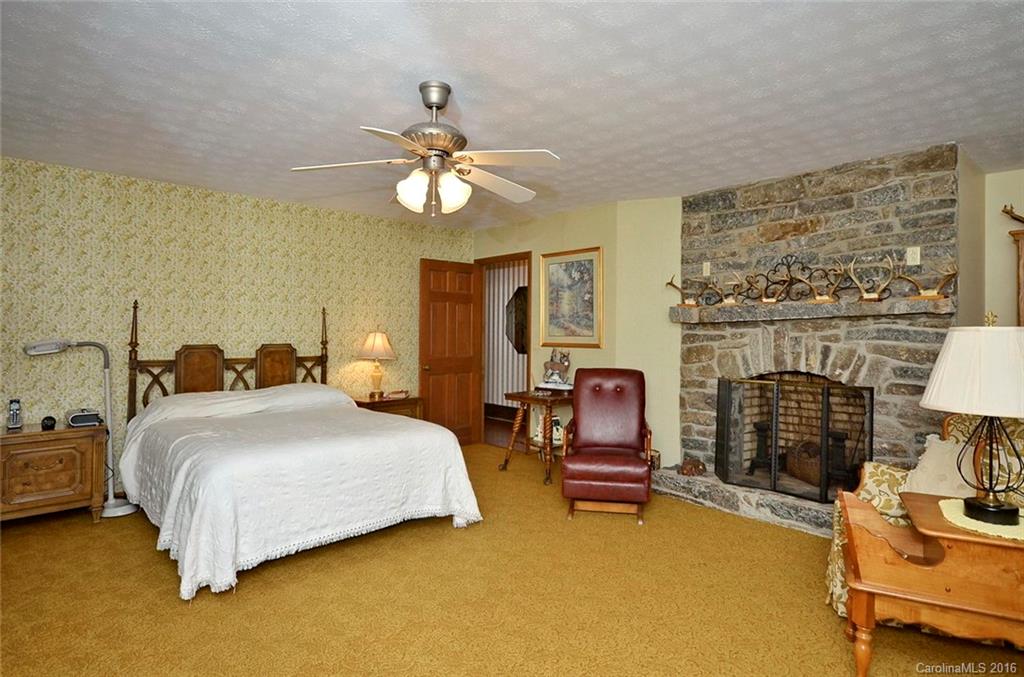 110-114 Hilltop Road Waynesville, NC 28786 - Photo 10 of 21 a bedroom with a bed furniture and a fireplace