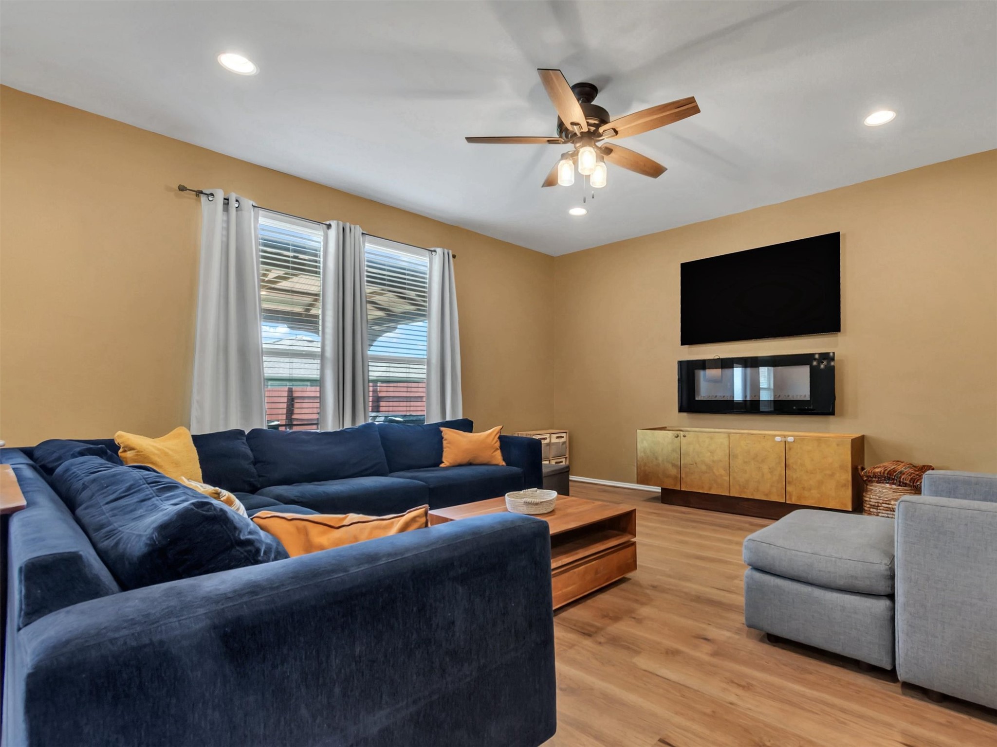 11701 Jackson Falls Way Manor, TX 78653 - Photo 13 of 40 Natural light bathes this comfortable living area, highlighted by a contemporary fireplace and a ceiling fan for optimal airflow.