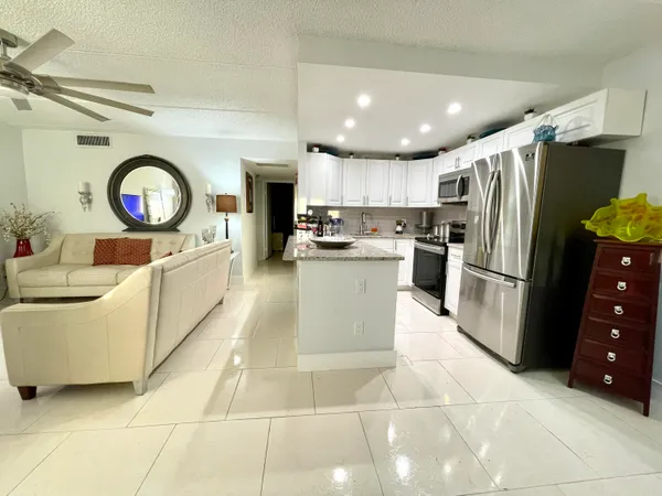 a kitchen with stainless steel appliances a stove a sink a refrigerator and a cabinets