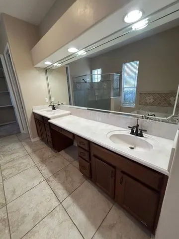 a bathroom with a sink double vanity granite and a mirror