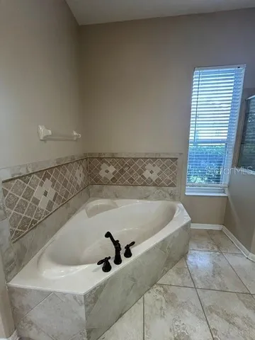 a bath tub sitting in a bathroom next to a window