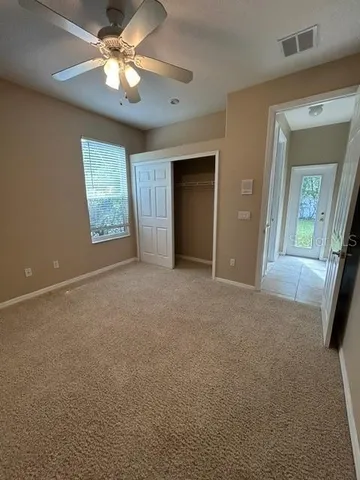 an empty room with windows and fan