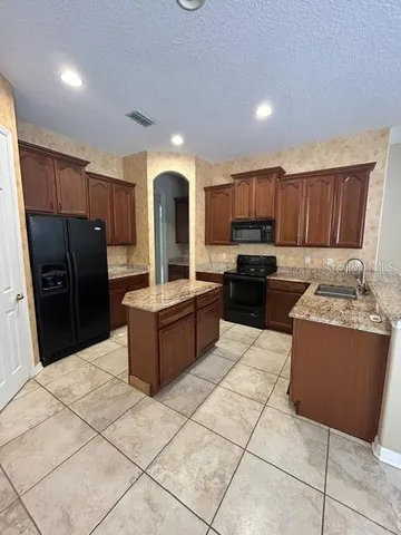 a kitchen with granite countertop a stove and a refrigerator