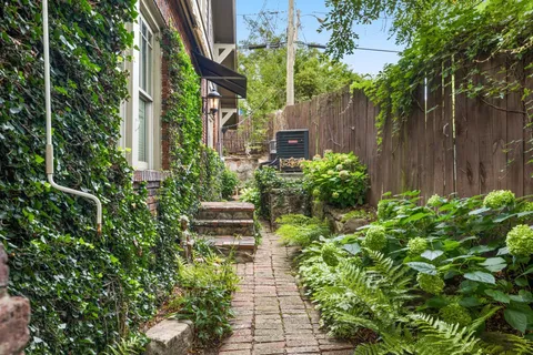 a view of house with backyard sitting area and garden