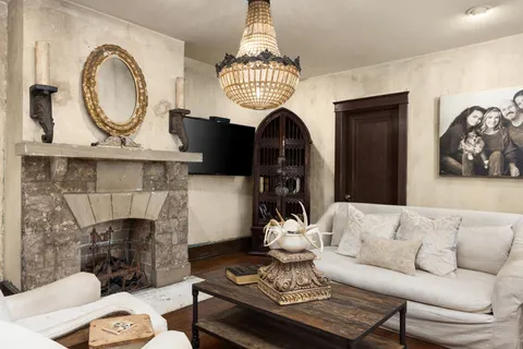 a living room with furniture a fireplace and a chandelier