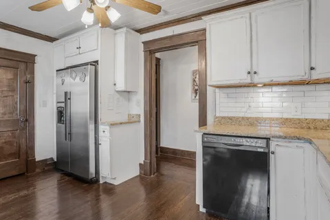 an empty room with wooden floor and cabinet