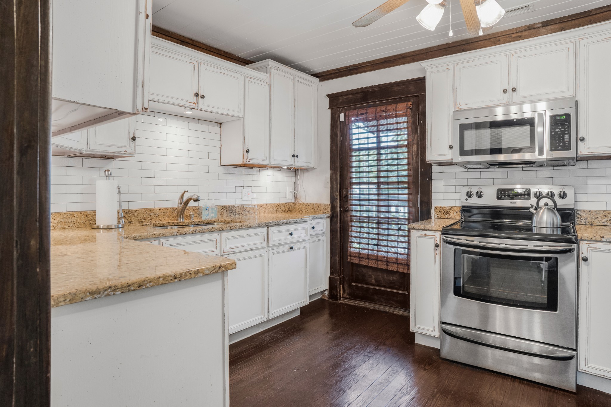 707 Inverness Avenue Nashville, TN 37204 - Photo 33 of 45 a kitchen with stainless steel appliances granite countertop a stove a sink and white cabinets
