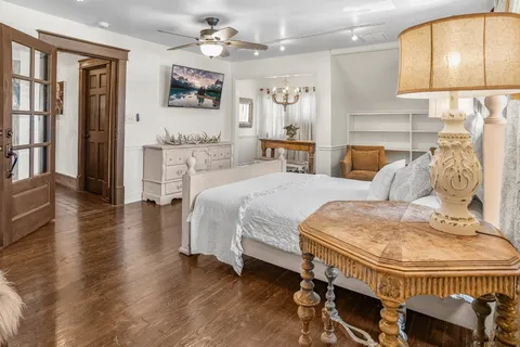 a spacious bedroom with a bed a mirror and furniture