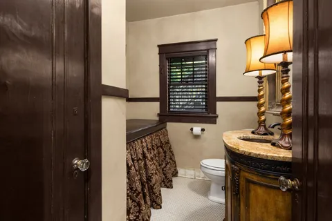 a bathroom with a granite countertop toilet a sink and a mirror