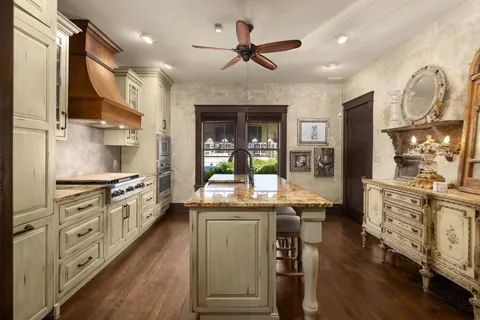 a kitchen with stainless steel appliances granite countertop hardwood floor sink stove dining table and chairs