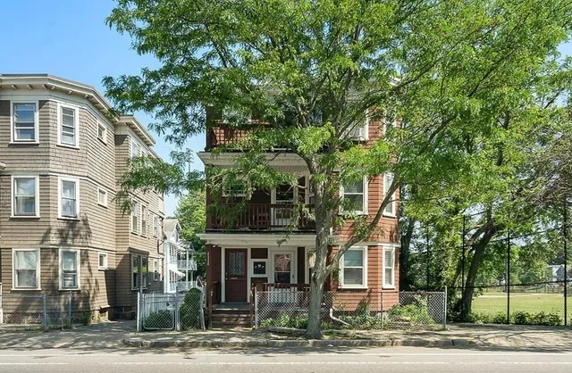a front view of a residential apartment building with a yard