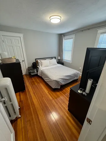 a bedroom with bed and wooden floor