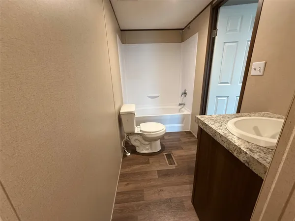 a bathroom with a granite countertop sink toilet and a mirror