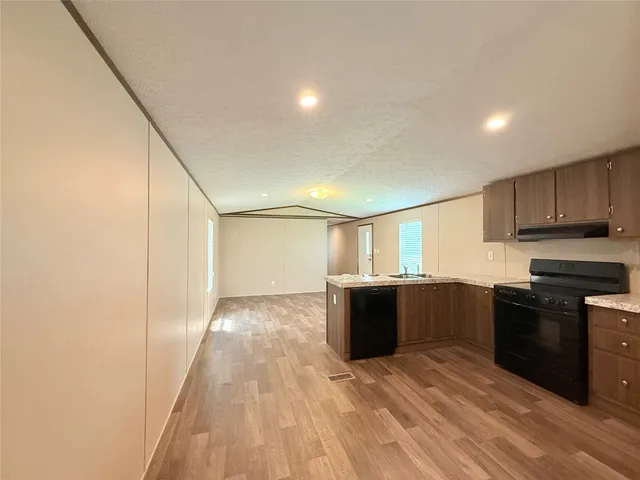 a large white kitchen with wooden floor