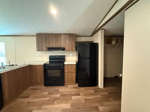 a kitchen with granite countertop a refrigerator stove and sink