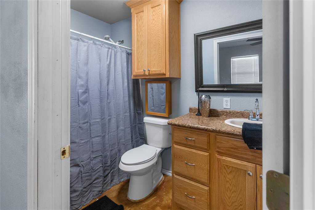 702 Main Windom, TX 75492 - Photo 13 of 30 a bathroom with a granite countertop sink toilet and shower