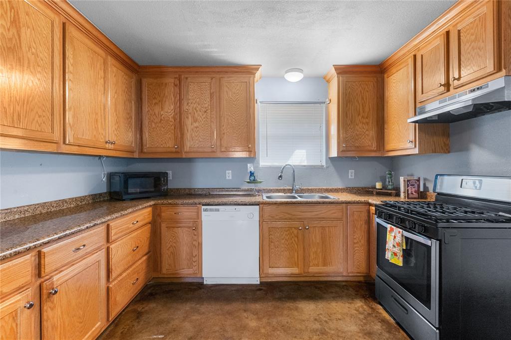 702 Main Windom, TX 75492 - Photo 3 of 30 a kitchen with stainless steel appliances granite countertop a stove a sink and a microwave