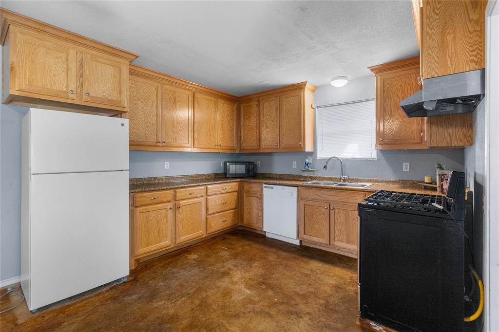 702 Main Windom, TX 75492 - Photo 4 of 30 a kitchen with granite countertop a refrigerator sink stove and cabinets