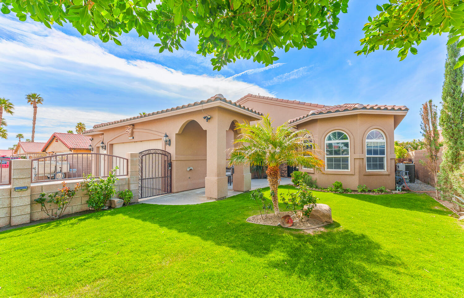 a view of a white house with a big yard plants and large trees